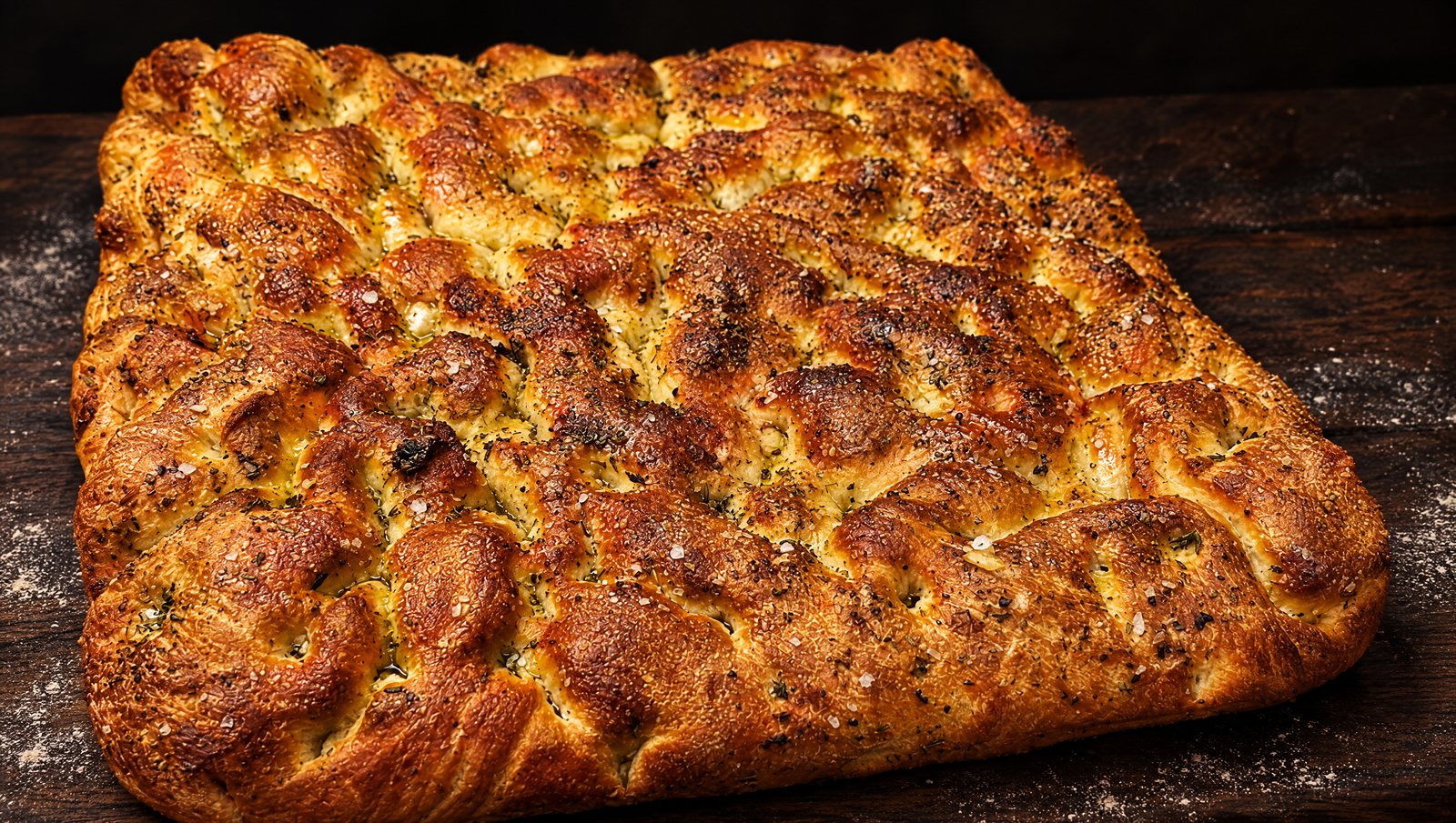A sheet of golden house focaccia with herbs and flaky salt
